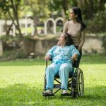 woman pushing a person with disability in a wheelchair